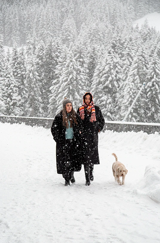 Paar und Hund im Schnee spazieren