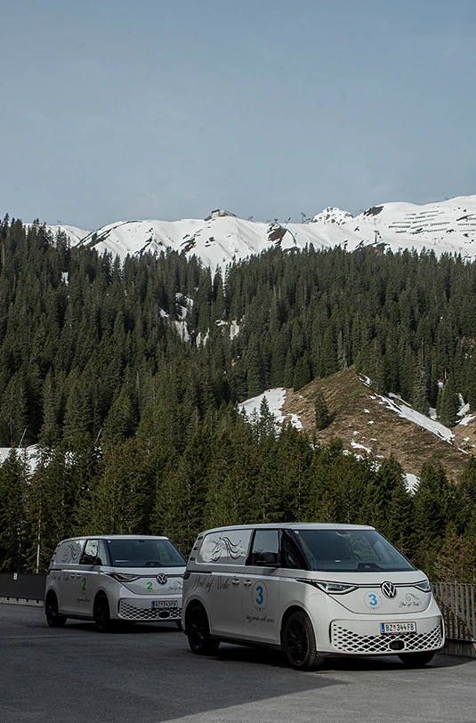 Zwei Autos vor schneebedeckten Bergen