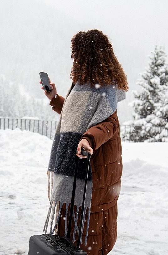 Frau mit Koffer im Schnee