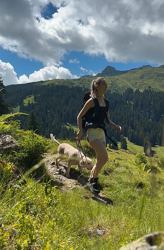 Frau wandert mit Hund in den Bergen